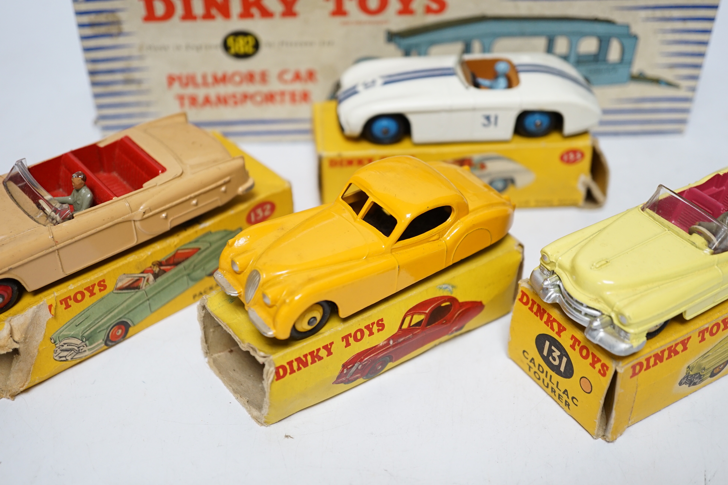 Five boxed Dinky Toys; (132) a Packard Convertible, (131) a Cadillac Tourer, (133) a Cunningham C-5R road racer, (157) a Jaguar XK120 and (582) a Pullmore Car Transporter with a (994) Loading Ramp, together with a Cresce